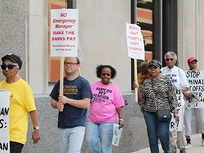 A coalition of activists protests outside the Detroit Water & Sewerage Department’s office in downtown Detroit on Friday, June 6.