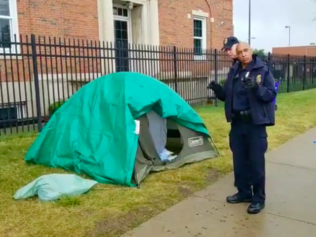 An officer with Homeland Security’s Federal Protective Services Police prepares to take down the remaining tents in Detroit's Occupy ICE encampment.