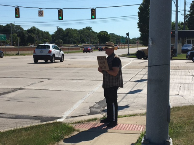 An MSP trooper poses as what very much resembles a panhandler at the intersection of Southfield Road and I-696 on Tuesday.