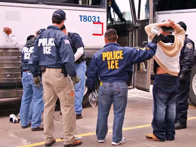 ICE special agents arresting suspects during a raid.