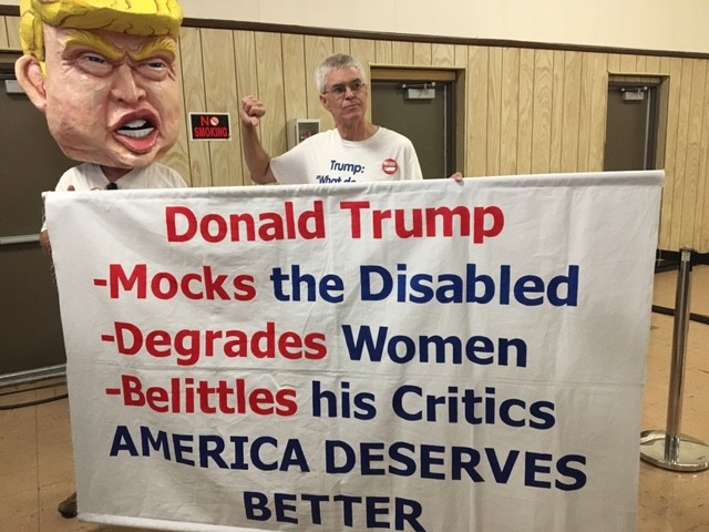 The Bernie Sanders event in Dearborn is warming up with Tom Moran, 61, a retired bus driver from Fenton, MI. He's been traveling the country protesting Trump.