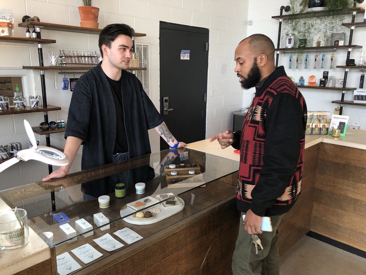 A budtender helps a customer at Detroit’s BotaniQ.