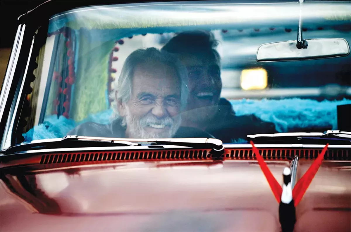 Image: Tommy Chong rides through Hazel Park in a replica of The Love Machine with his son, Paris.