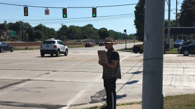 An MSP trooper poses as what very much resembles a panhandler at the intersection of Southfield Road and I-696 on Tuesday.