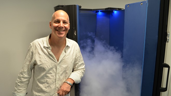 Eric Spector with the cryotherapy chamber at CryoWorks Michigan in Berkley.