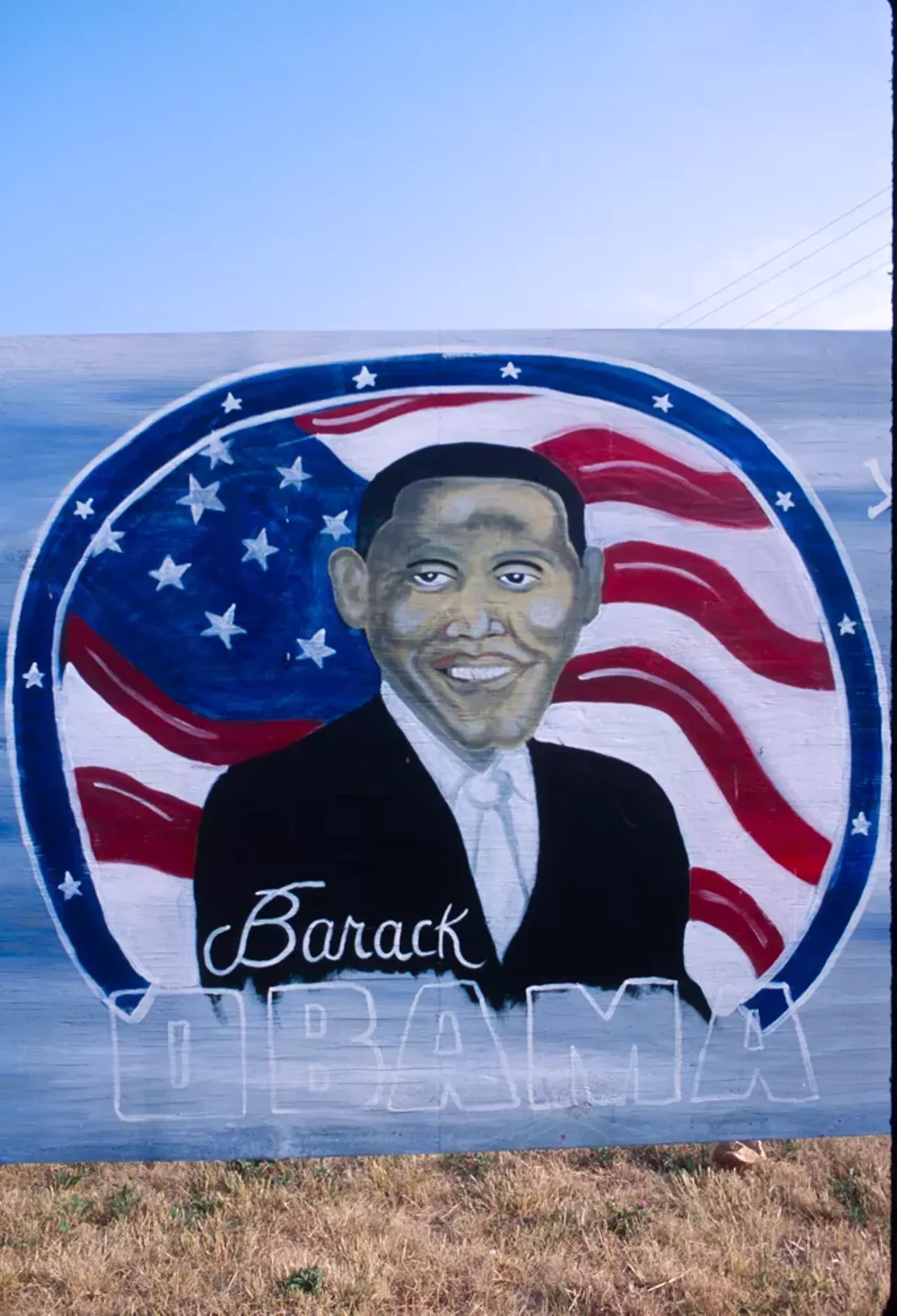 In his article today, Vergara notes that " Folk portraits of [Obama] express pride that a black person was able to achieve the presidency, something few believed possible. He is often accompanied by such symbols of American power as ... the American flag." Here, Obama is all but wrapped in the banner, in a piece Vergara found in 2012, painted onto a sign at East Forest and Van Dyke in Detroit.