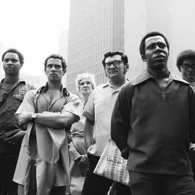 Eight people intently watching a protest rally in Detroit - "I like taking photos of people when I know for sure they're looking at something else."