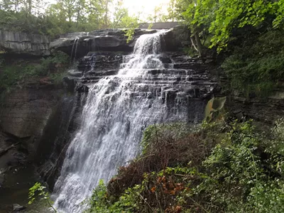 The Cuyahoga Valley National Park Estimated time: 2 hours, 41 minutes Situated between Cleveland and Akron, there's actually something pretty beautiful. The Cuyahoga Valley National Park is filled with waterfalls, rolling hills, caves, ravines, and winding rivers. The Ledges provides a boulder-strewn cliff to relax and watch the sunset over the wooded scenery below, and the park offers an array of preserved and restored displays of 19th and early 20th century sustainable farming and pastoral or rural living, while catering to contemporary interests with art exhibits, outdoor concerts, and scenic excursion and special event railroad tours.