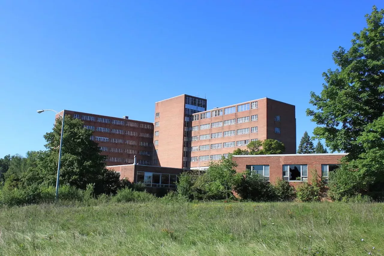 Northville Psychiatric Hospital 41000 Seven Mile Rd., Northville Opened in 1952 and closed 50 years later, this hospital might just be home to some patients that have yet to leave. At the time, this Northville facility was touted as Michigan's first attempt at scientific treatment of mental illness, and had everything from a movie theater, bowling alley, and therapeutic baths available to patients. However, the tunnels, which were designated as fallout shelter at the height of the Cold War, have been the source of some of the facility's spookiest paranormal shit, like hearing voices, footsteps, and clanking chains. Some have even reported having experienced touch and breathing down their necks by the unseen. While the asylum is no longer standing, it is said to be surrounded by a creepy-ass forest where many of the spirits have allegedly relocated to. Photo via Northville Psychiatric Hospital/Wikipedia Commons