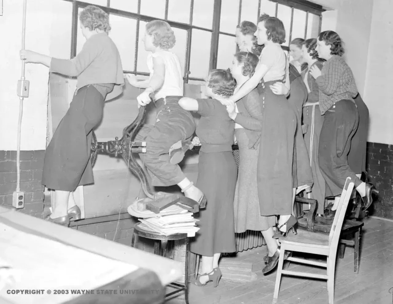 1930s | Striking female employees stand on chairs and window ledge to look out windows of the Yale & Towne Manufacturing Company building during sit-down strike in Detroit, Michigan. "In the Thirties, Yale & Towne resisted unionization so bitterly that it closed a plant in Detroit rather than deal with a union, at one point a federal judge censured the company for its anti-labor activity," from Rainbow at Midnight: Labor and Culture in the 1940s, by George Lipsitz.