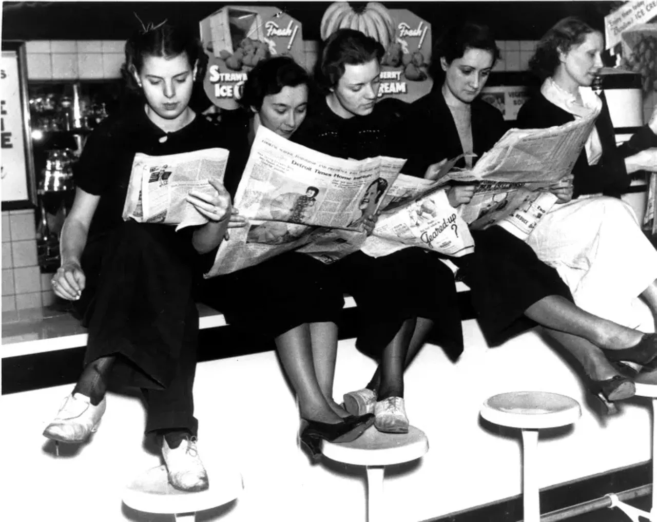 1930s | Five women sit on lunch counter reading newspapers at Woolworth store in Detroit, Michigan during sit-down strike.