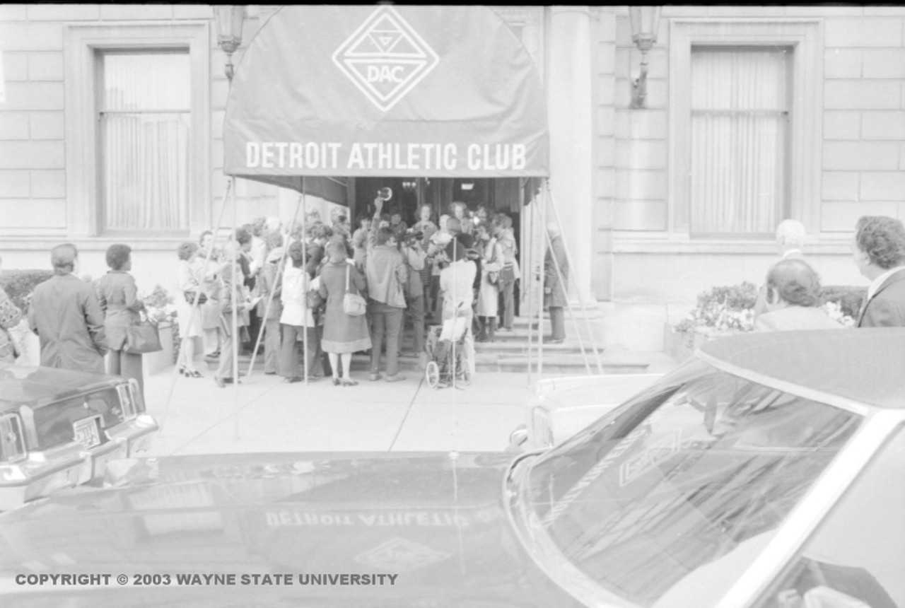 1970s | Group of women from the National Organization for Women stand under the awning at the entrance to the Detroit Athletic Club.