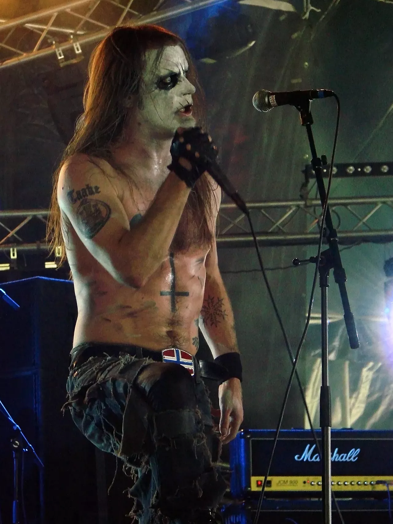 Taake takes his corpse paint in a more rotting direction. Additionally, Taake is one of the few black metal artists to extend the corpse paint to his toned abs.