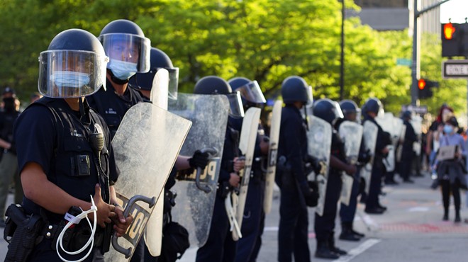 Detroit police clad in riot gear form a barricade outside Public Safety Headquarters.