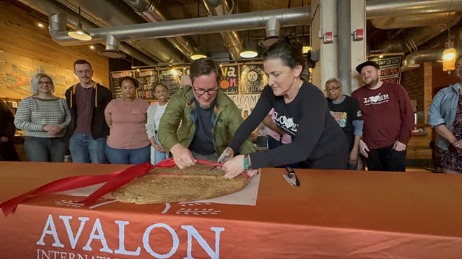 Jolly Pumpkin co-founder Jon Carlson (center left) and Avalon owner Jackie Victor (center right) cut a giant cookie at Avalon on Canfield’s grand opening.