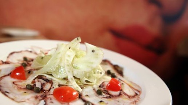 Carpaccio di Polipo, thinly sliced octopus, fennel, celery, grape tomatoes, capers, lemon, extra-virgin olive oil, front, with mural, back, from Bella Piatti in Birmingham.