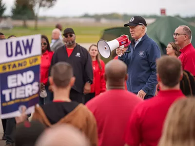 President Joe Biden, alongside UAW President Shawn Fain, speaks on the UAW picket line at Willow Run Redistribution Center in Belleville, Mich., Sept. 26, 2023.