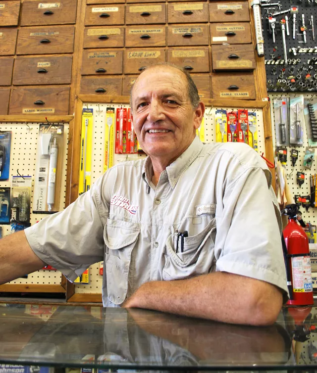 Dave Zammitt stands before the antique wood cabinets in his store.