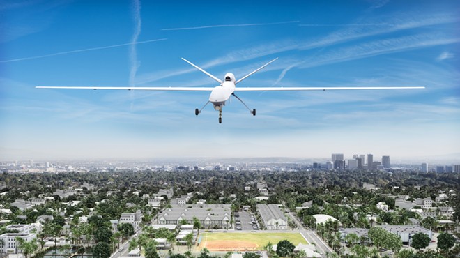 Surveillance UAV drone flying over a residential neighborhood.