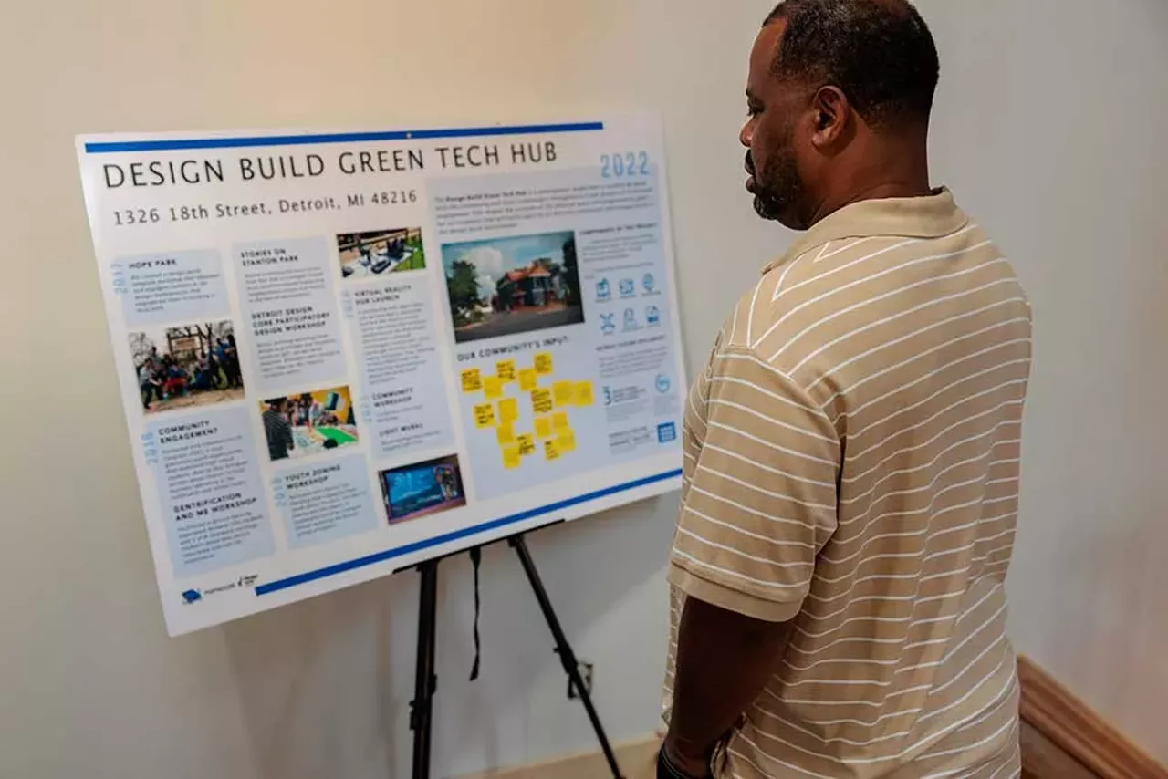 A community member reads one of the informational boards displayed inside the Design Build Green Tech Hub during the grand opening on September 14, 2024.