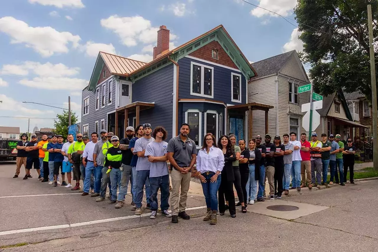 A group of contractors, local leaders, and family members involved in the renovation of the Design Build Green Tech Hub stand behind Luis Ali and Tanya Saldivar-Ali (center) outside the historic building in Detroit’s Hubbard Richard neighborhood on July 19, 2024.