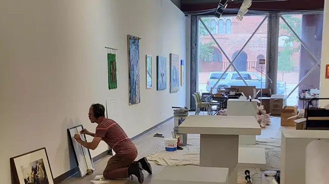 A worker puts the finishing touches on the Detroit Artists Market ahead of its first exhibition since it was remodeled.