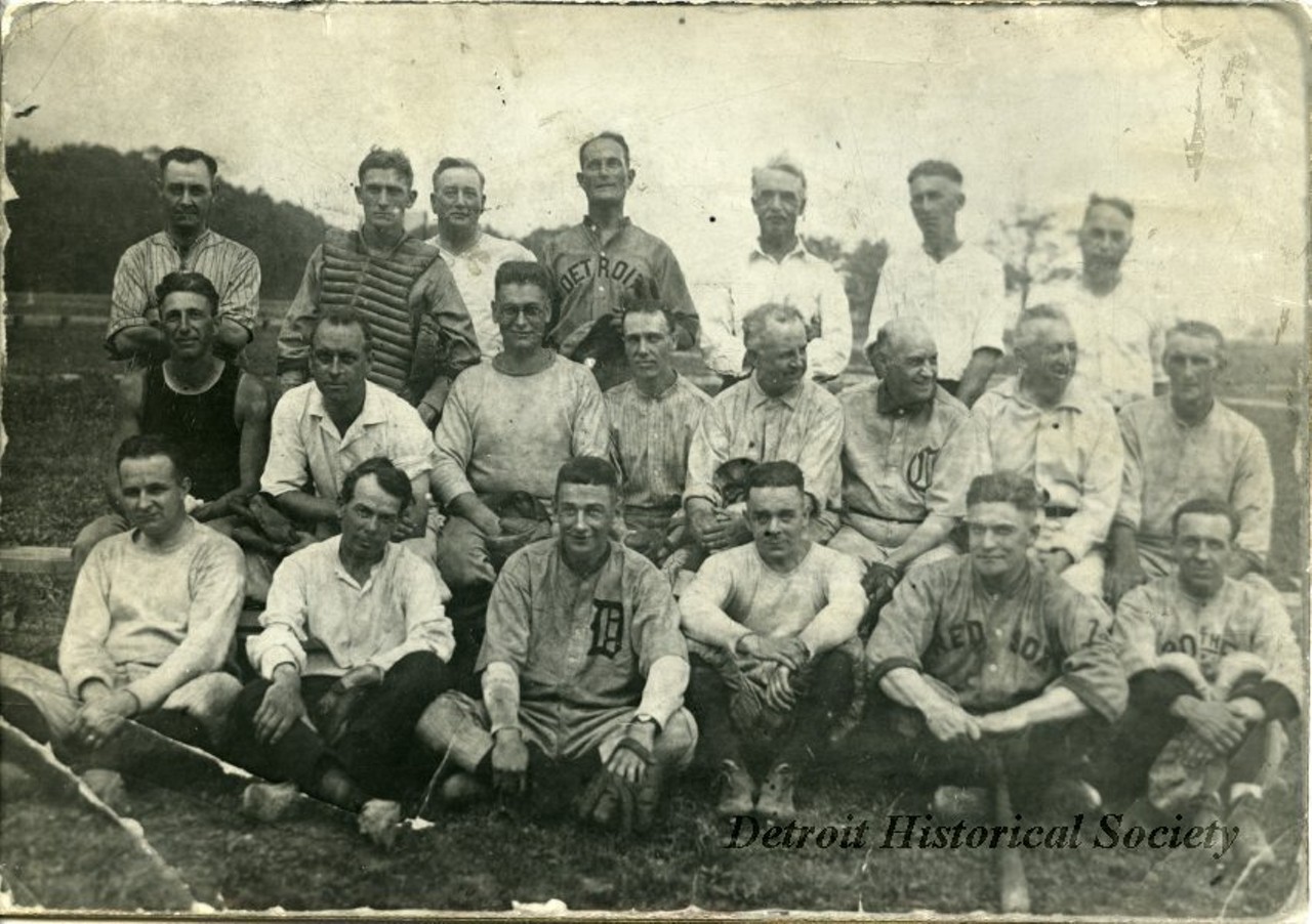 "Black and white photographic print depicting a group of baseball players, presumably members of the Old Time Base Ball Players' Association. A few of the men wear Detroit Tigers uniforms while another wears Boston Red Sox uniform. Dated July 4, 1919."
