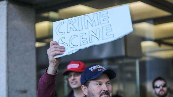 A Trump supporter wielding a sign alleging voter fraud outside of Detroit's TCF Center.