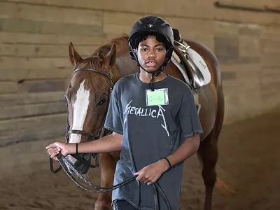 Detroit Horse Power program student Charles Johnson, 13, walks his horse around the training ring at Willowbrooke Farm in Plymouth.