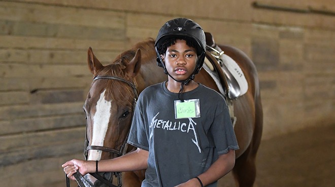 Detroit Horse Power program student Charles Johnson, 13, walks his horse around the training ring at Willowbrooke Farm in Plymouth.