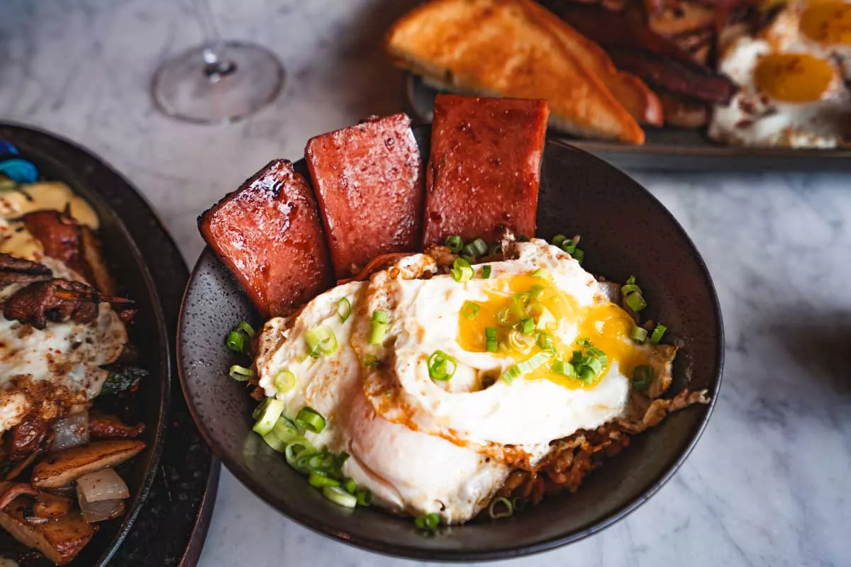 Image: Tigerlily’s new weekend brunch menu includes a Pacific islands twist on breakfast favorites, like Eggs Benedict served over a bao bun with spam.