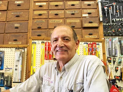 Dave Zammitt stands before the antique wood cabinets in his store.