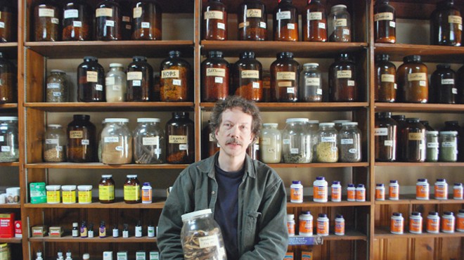 Gary Wanttaja stands before his jars of herbs.