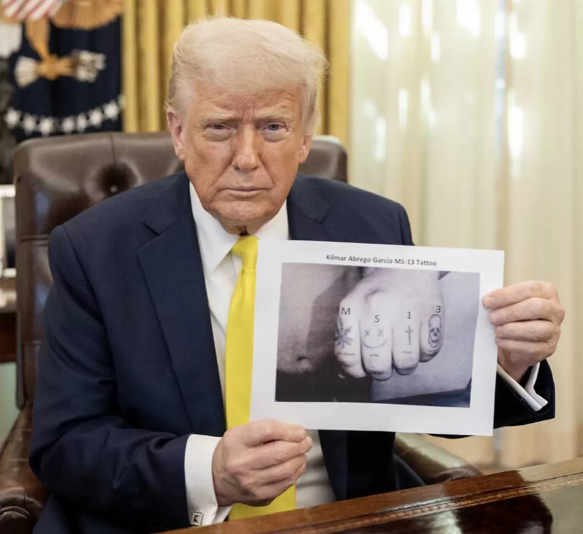 Image: President Donald Trump holds up a photo purporting to link Kilmar Armando Abrego Garcia’s tattoos to the gang MS-13.