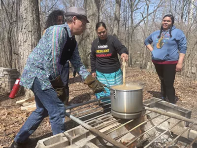 Community members boil and stir the maple syrup.