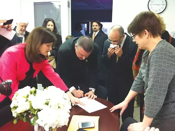 James Ryder, 48, and Frank Colasonti, 61, the first same-sex couple married at Oakland County Circuit Court Saturday, March 22, make it official with County Clerk Lisa Brown and their two witnesses, Jan Stevenson, publisher of Between the Lines, and Susan Horowitz. - Ryan Felton