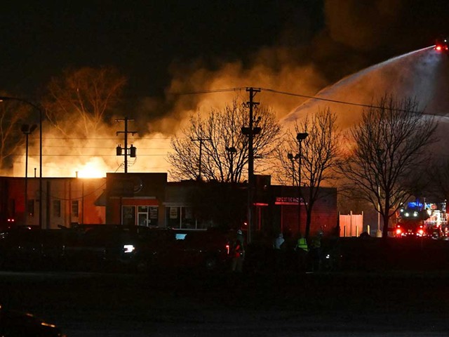 Fire departments battle an industrial fire near 15 Mile Road and Groesbeck Highway in Clinton Township on Monday.
