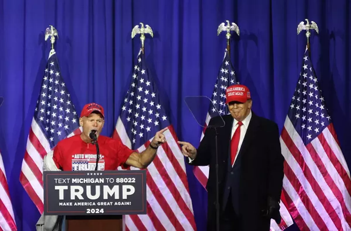 Image: “Look at these muscles”: Former President Donald Trump brings a retired autoworker on stage at a Waterford rally.