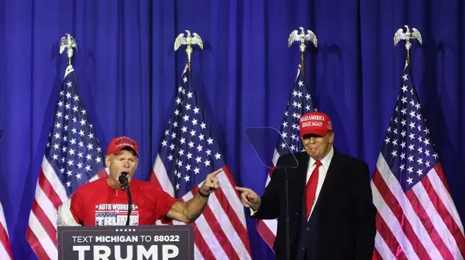 “Look at these muscles”: Former President Donald Trump brings a retired autoworker on stage at a Waterford rally.