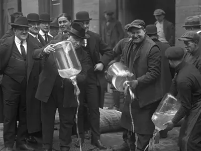 Dumping illegal booze in the gutter after a 1922 raid in New York City.