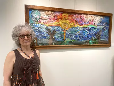 Deborah Hecht next to her piece "Beach Trash Sunset."