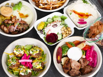 Counterclockwise bottom left to right: Loaded falafel, fooul, shawarma fries, hummus, beef tenderloin bowl, and salad.