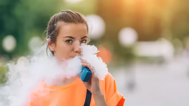 A young woman vaping nicotine.