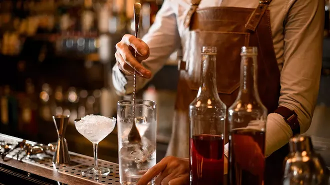 A bartender makes cocktails.