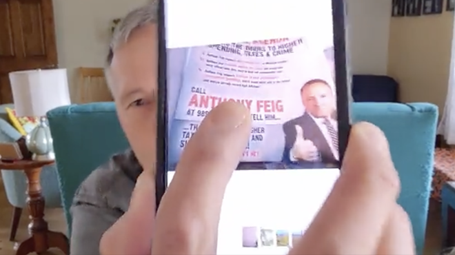 Anthony Feig, a Democrat running for state House, shows a political ad from his opponents that featured his cellphone number.