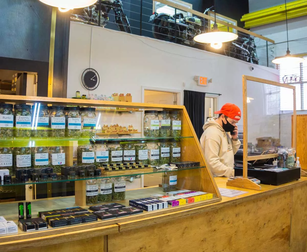 Image: A cashier at the Utopia Gardens cannabis dispensary in Detroit.