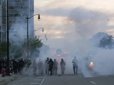Detroit police deploy tear gas and rubber bullets as protesters flee.