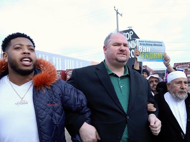 Former state Rep. Isaac Robinson (center) locks arms with state Rep. Jewell Jones (left) and Imam Salah Algahim (right) as they march from a nearby school to protest U.S. Ecology on Detroit's east side.