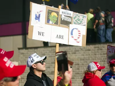 A protester holds a sign referencing the QAnon conspiracy theory at a rally for President Donald Trump in Detroit.