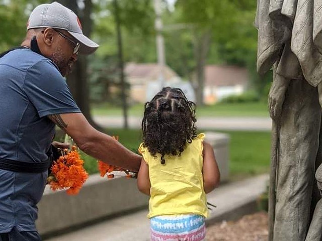 Plaintiff Tony Miller with his daughter at a statue in the Garden of Honor in Allendale Township, where he wanted to inscribe a brick with the phrase "Black Lives Matter” or “Indigenous Lives Matter.”